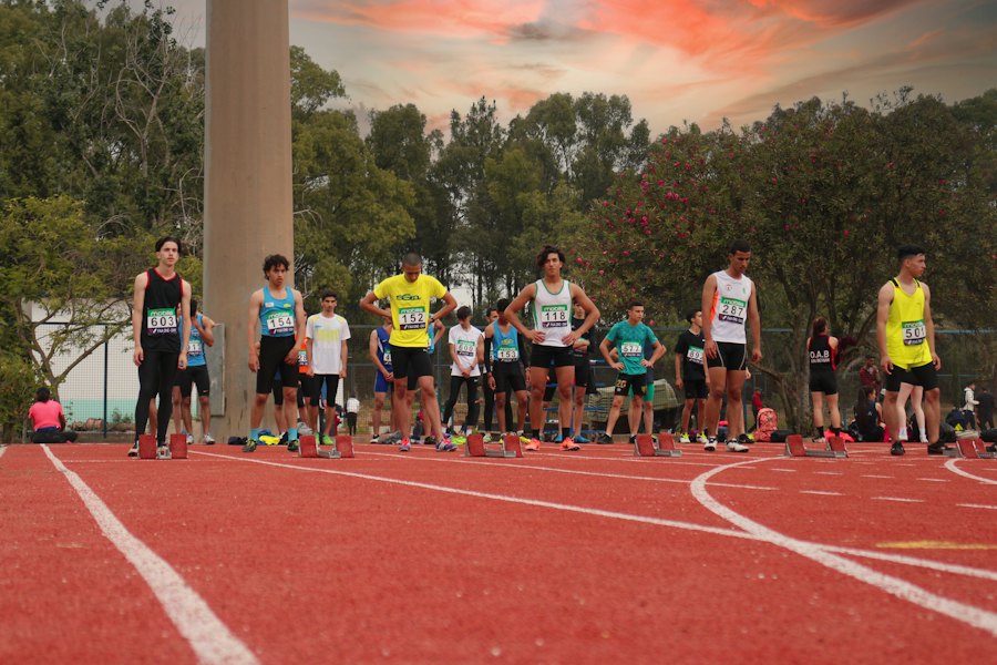 Grupo de corredores preparándose en una pista de atletismo